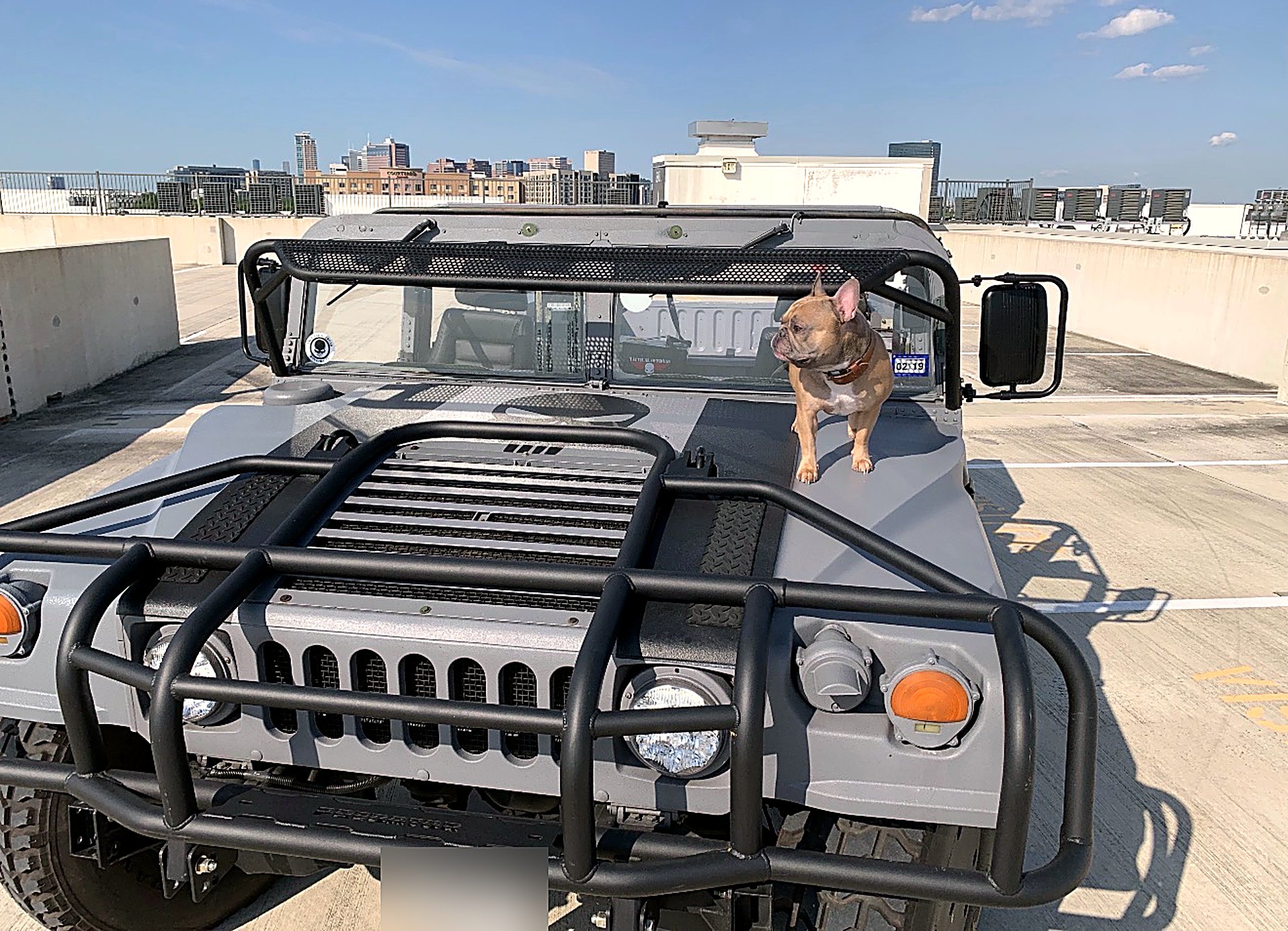 LuxeHaus HMMWV on a rooftop overlooking the downtown skyline